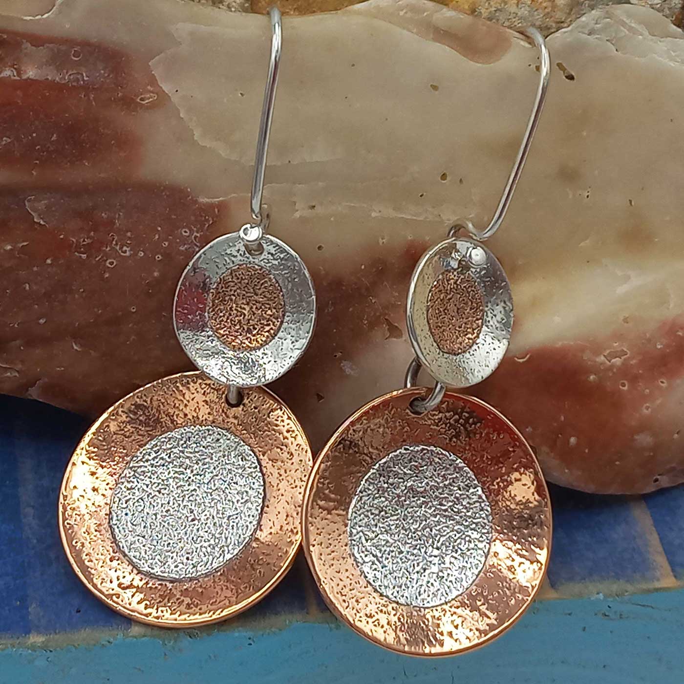 Pair of statement earrings with circular design on a shell surface