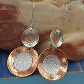 Pair of statement earrings with circular design on a shell surface