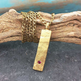 Gold plated bar necklace with red glass stone