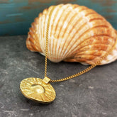 Brass etched Moneta circle pendant with gold plated extendable chain