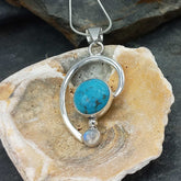 Silver pendant with turquoise and moonstone on a shell