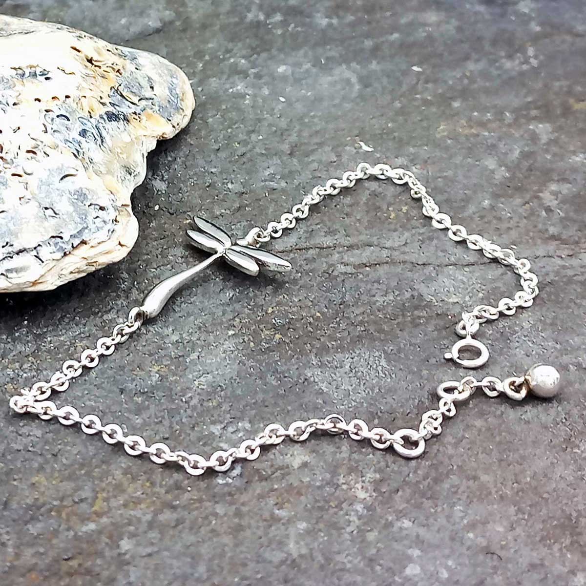 Silver bracelet with a dragonfly on a stone surface