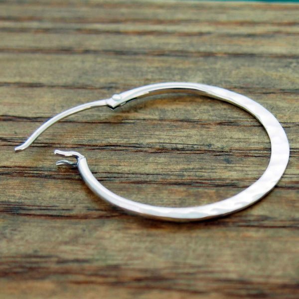 Silver hoop earrings on a wooden surface