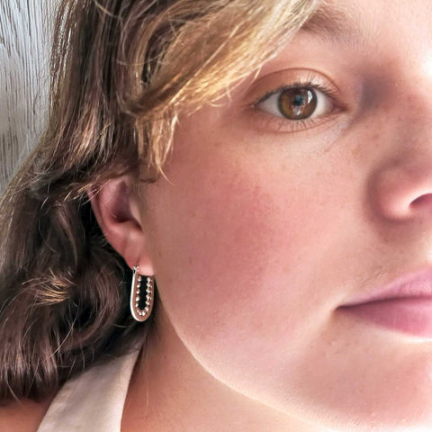 Oval silver hoop earring with balls