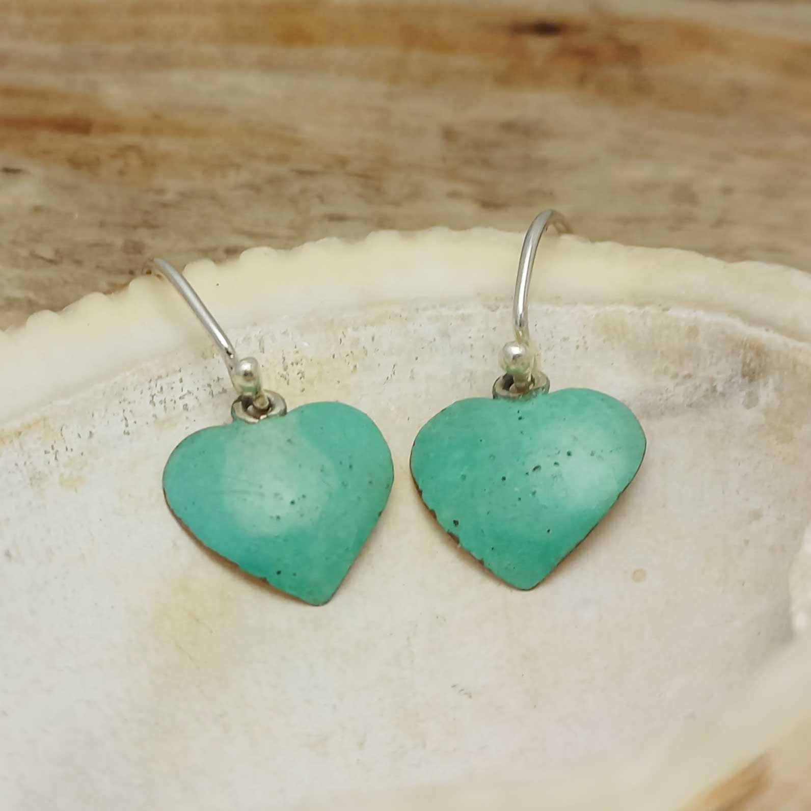 Unusual Turquoise heart-shaped earrings on a shell 