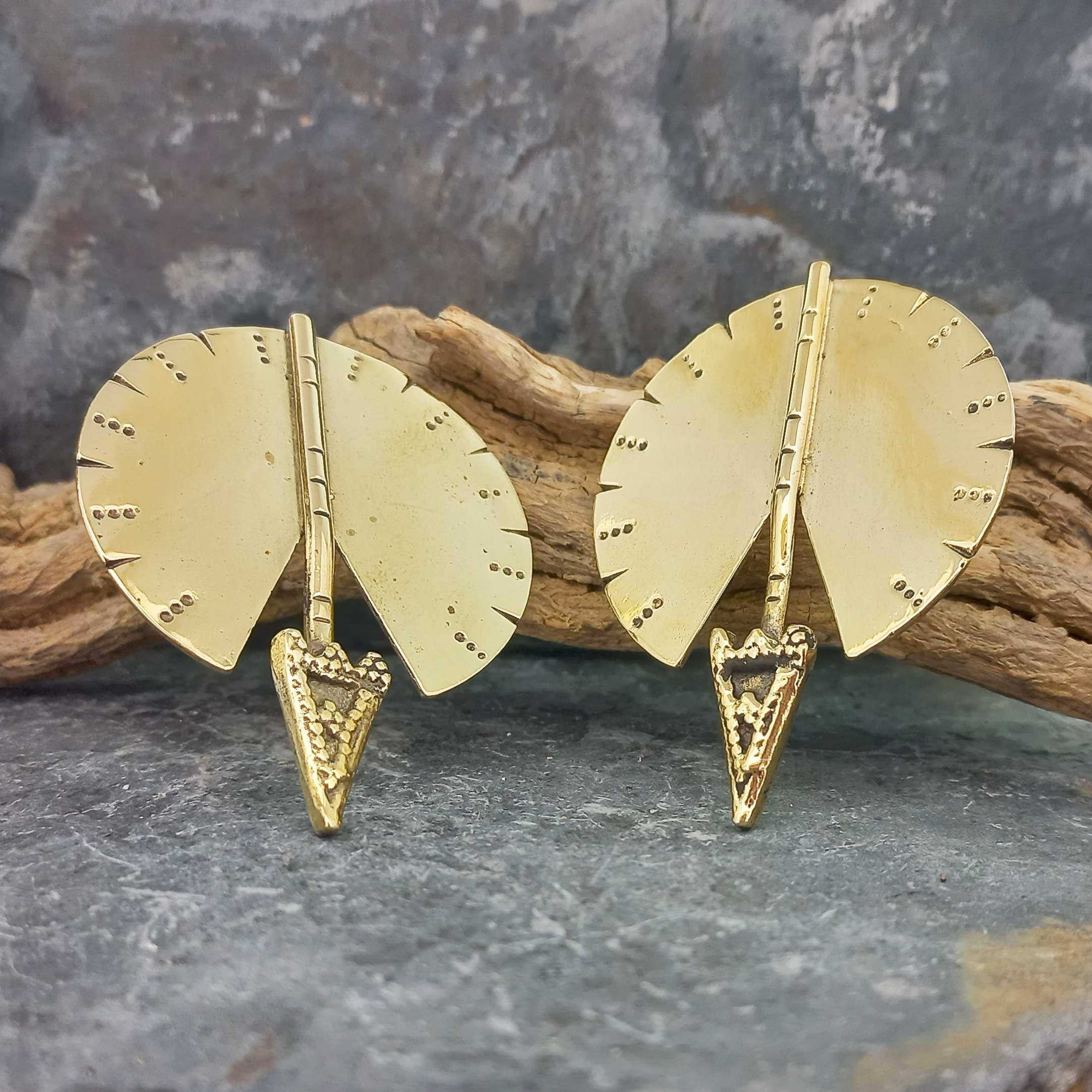 A pair of gold-toned arrow-shaped unusual stud earrings with fan-shaped backplates and textured triangular tips.