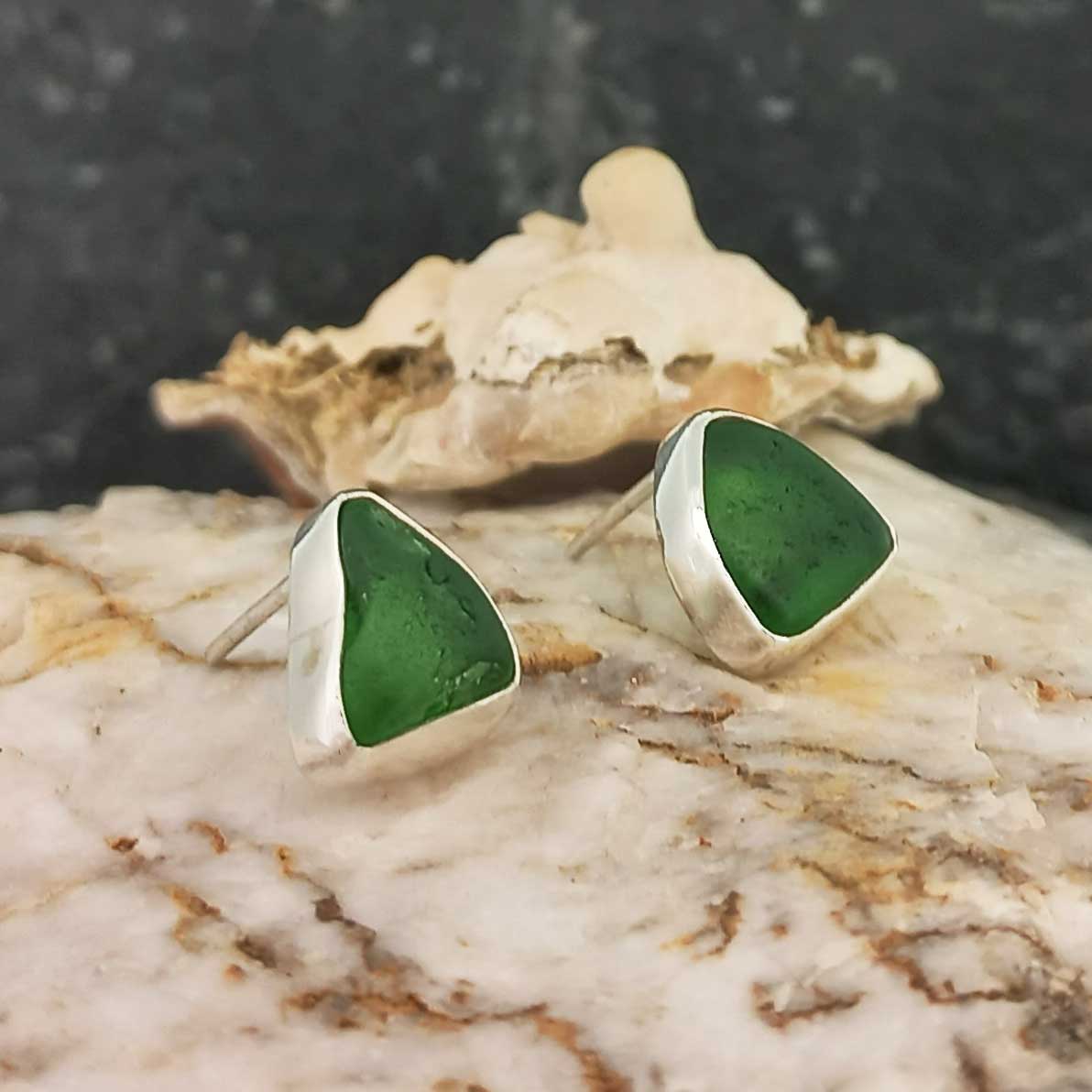 A pair of handmade recycled green glass stud earrings.
