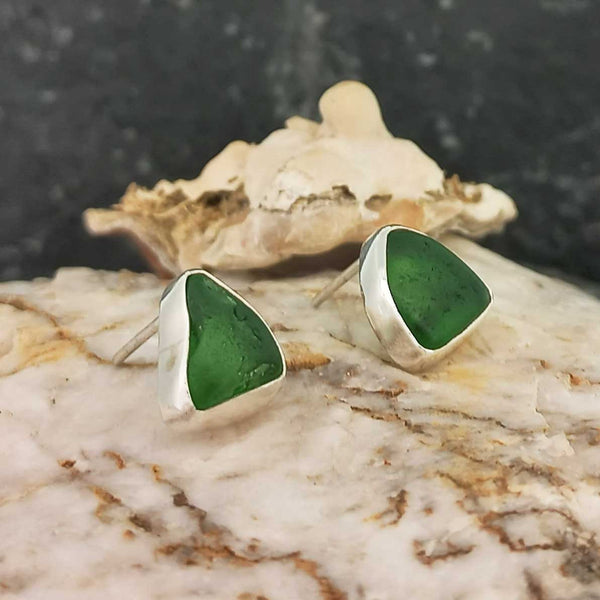 A pair of handmade recycled green glass stud earrings.