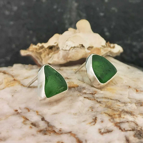 A pair of handmade recycled green glass stud earrings.