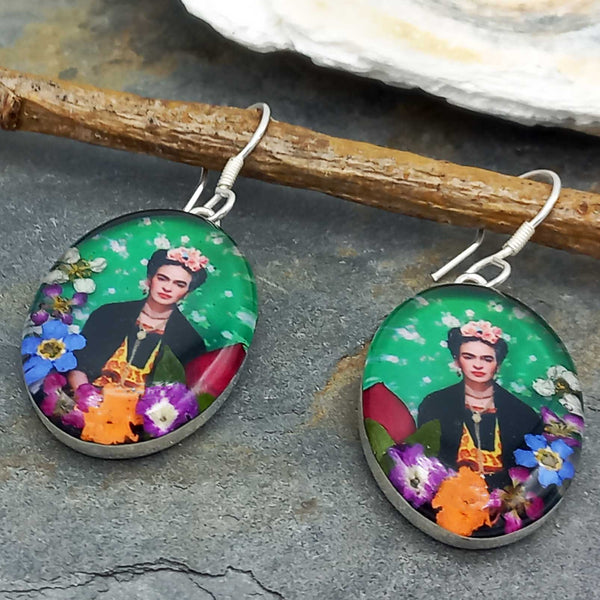 Frida Kahlo earrings with colorful design on a stone surface