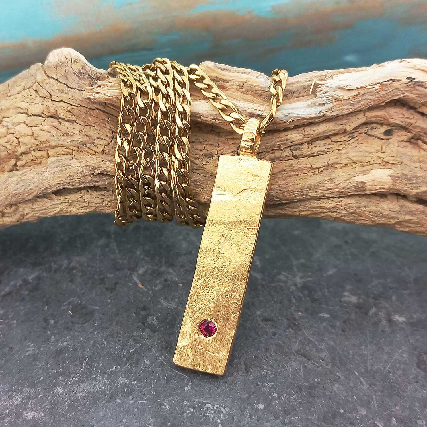 Gold plated bar necklace with red glass stone