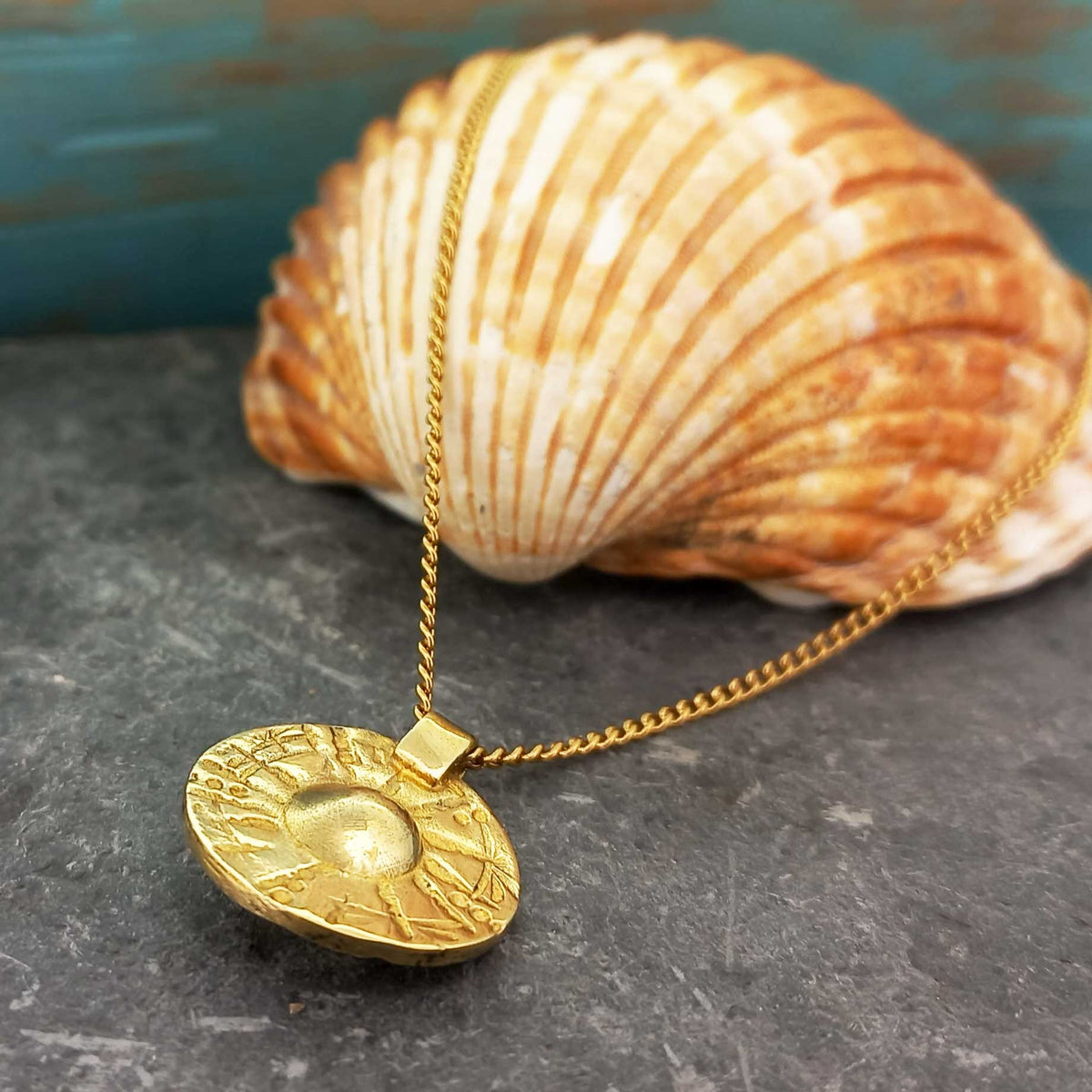 Brass etched Moneta circle pendant with gold plated extendable chain