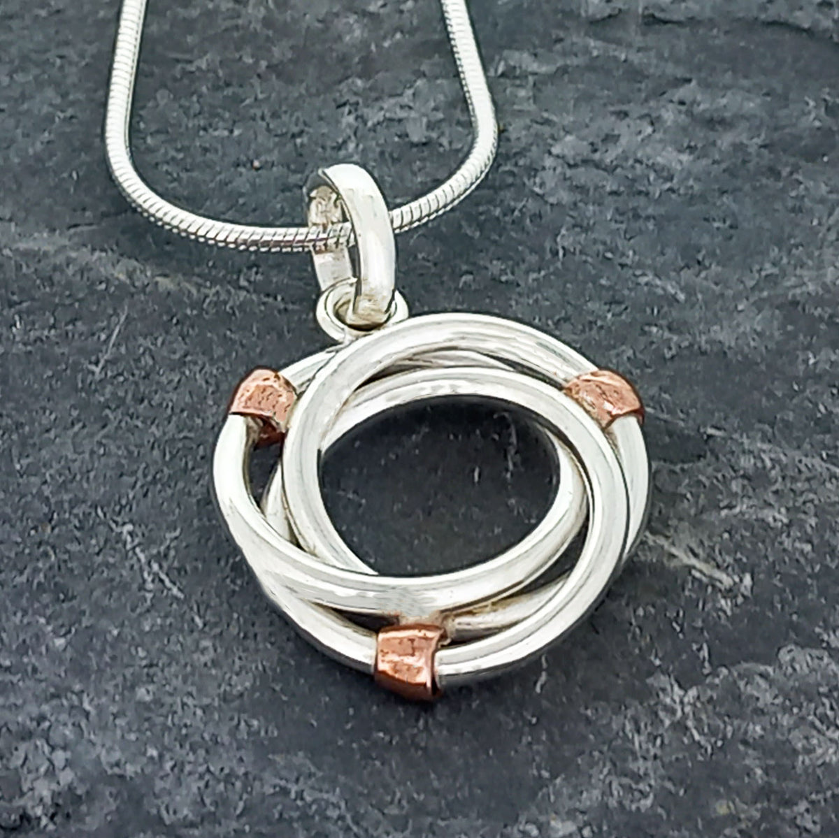Silver circle with copper bead pendant Main image