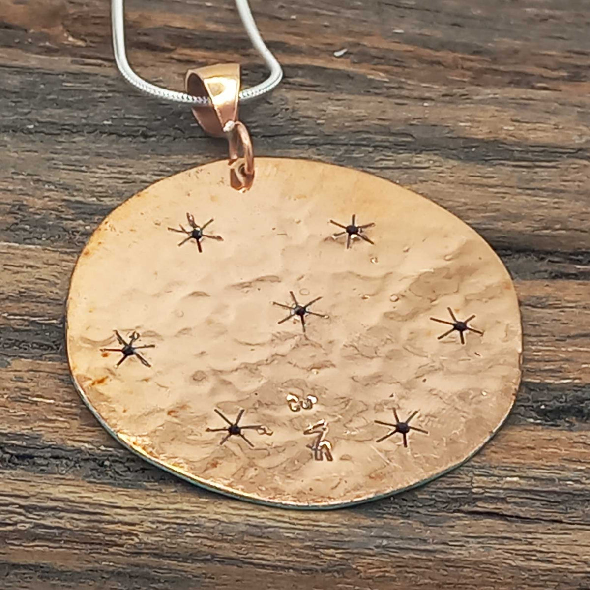 Back of patina copper pendant with stars