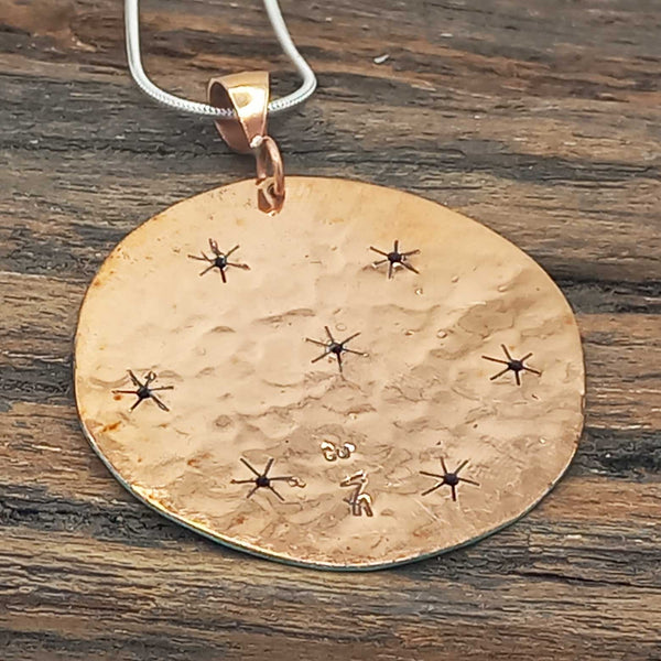 Back of patina copper pendant with stars