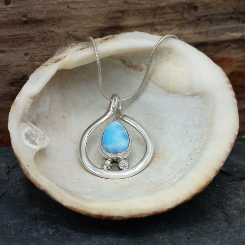 Silver necklace with a blue Larimar teardrop stone in a shell