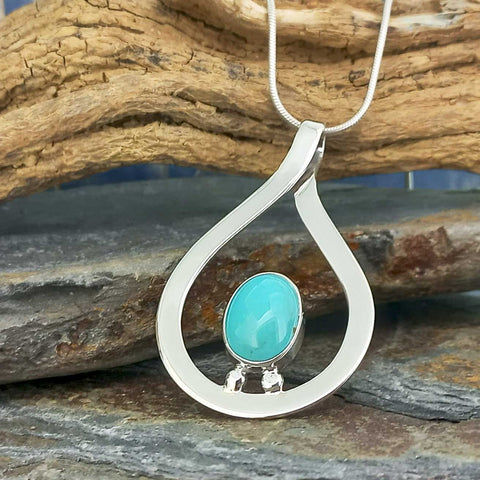 A sterling silver teardrop-shaped pendant necklace with a smooth, oval turquoise-blue stone in the centre