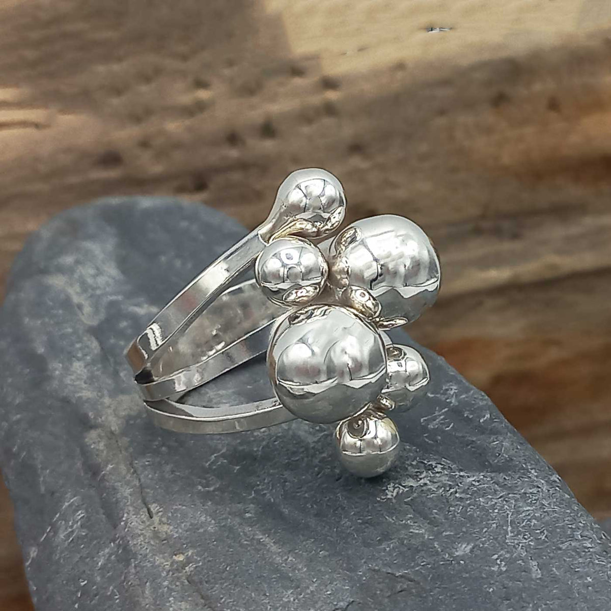 Silver ring with bubble design on a stone surface