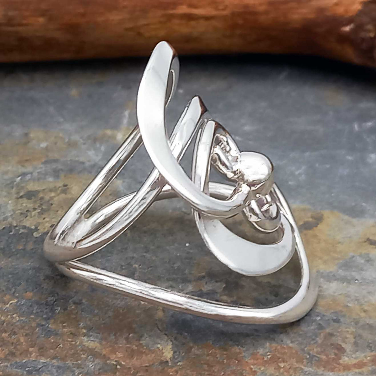 Silver ring with a unique design on a stone surface