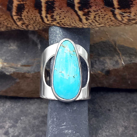 Silver ring with a turquoise stone on a textured surface