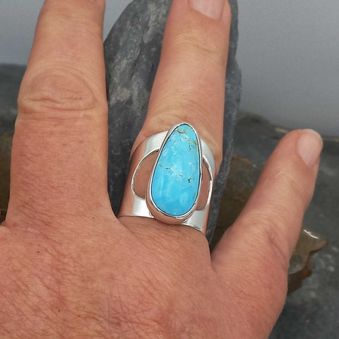 Turquoise ring on a person's finger.