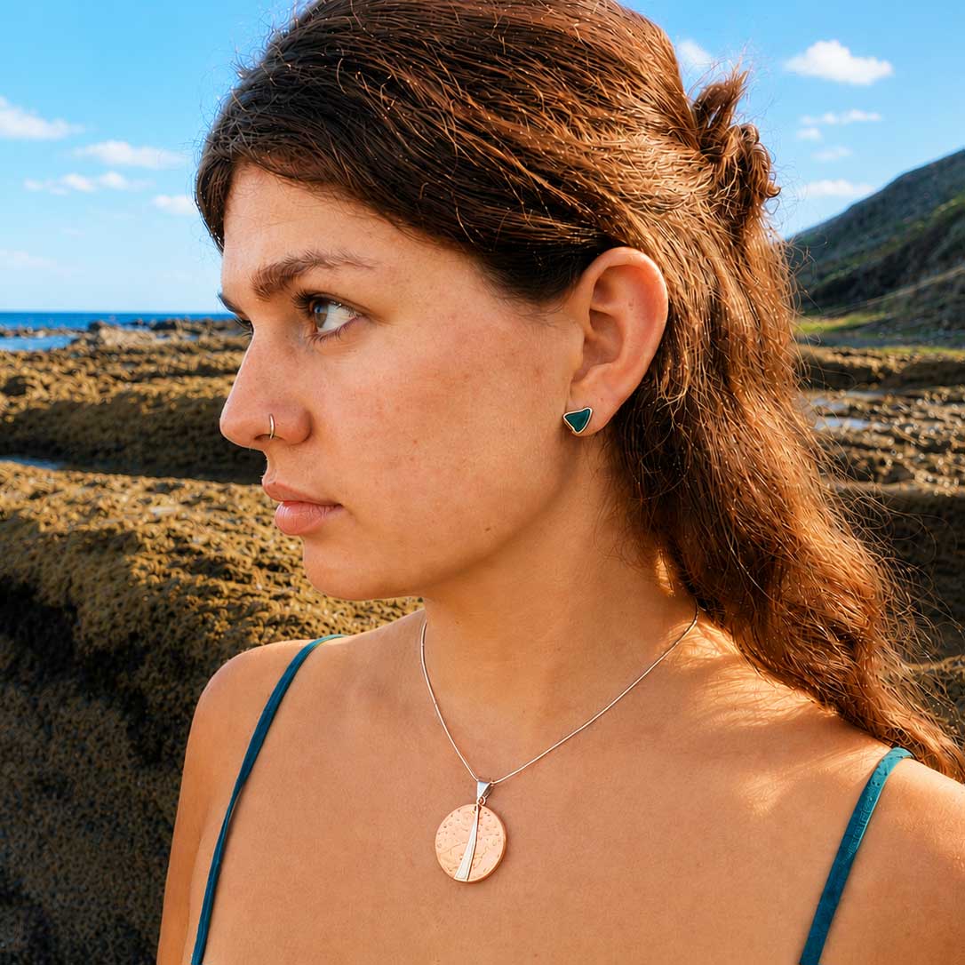 Model wearing copper hammered handcrafted pendant with silver detail
