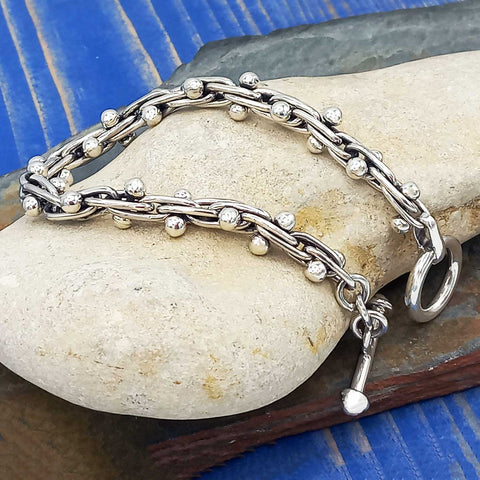 Silver chain bracelet with balls on a stone surface 